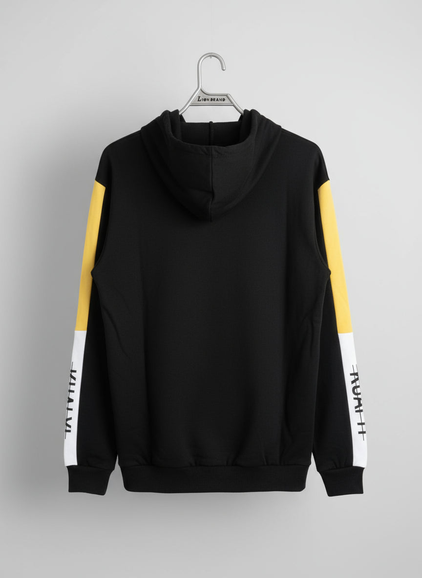 Black hoodie with yellow sleeves on a hanger against a textured wall.