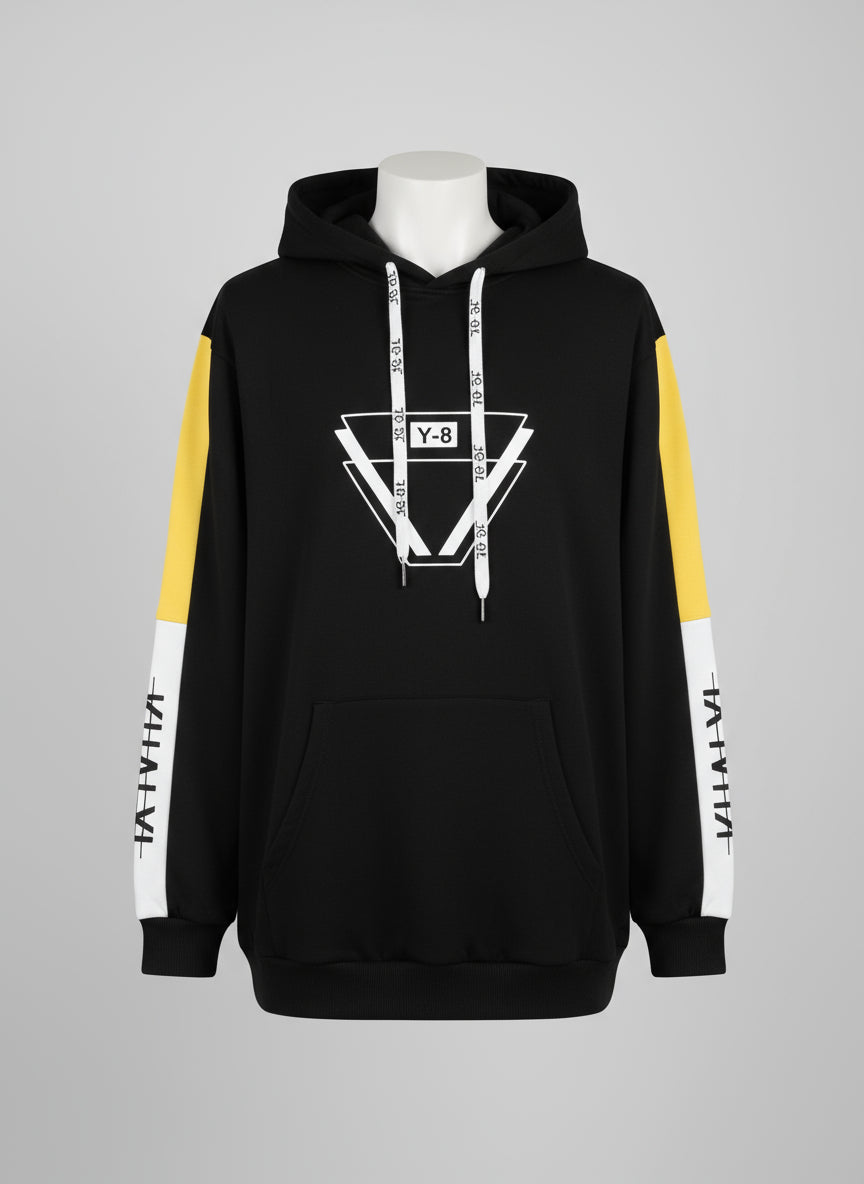 Black hoodie with yellow and white accents, featuring a brand logo, held against a textured wall.